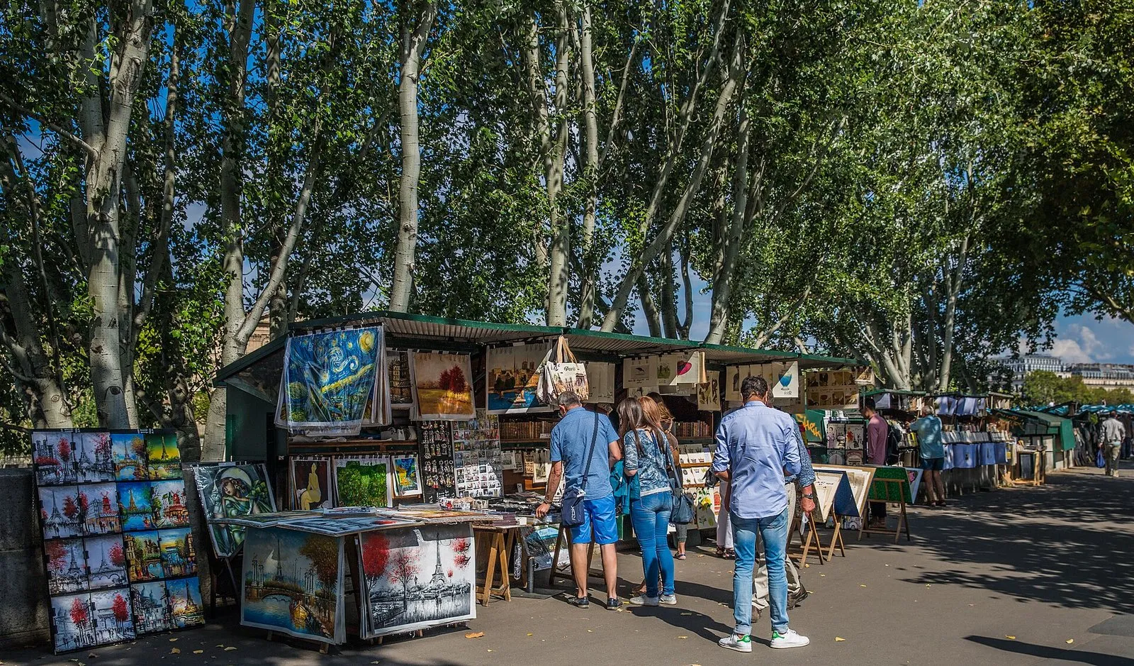 Des bouquinistes sous les platanes, au bord de la Seine